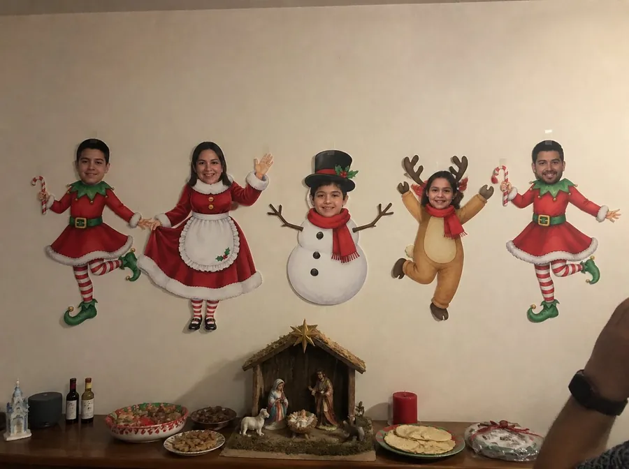 Pared de la sala con la familia convertida en personajes navideños